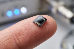 Miniatur-Photodioden-Sensor auf einer Fingerspitze zum Größenvergleich für tragbare Gesundheitsgeräte