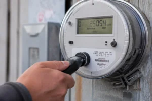 Ein Techniker verwendet eine Infrarotsonde an der optischen Schnittstelle eines Smart Meters, die mit einer hochempfindlichen PIN-Fotodiode zum Auslesen von Smart-Meter-Daten ausgestattet ist