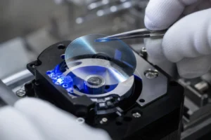 A professional cleanroom assembly scene showing a high-precision glass code disc illuminated by a specialized custom encoder LED